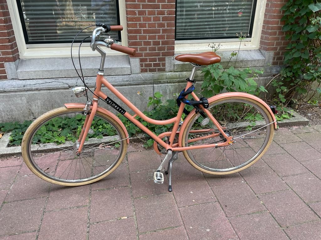 Terracotta Veloretti city bike parked on the street